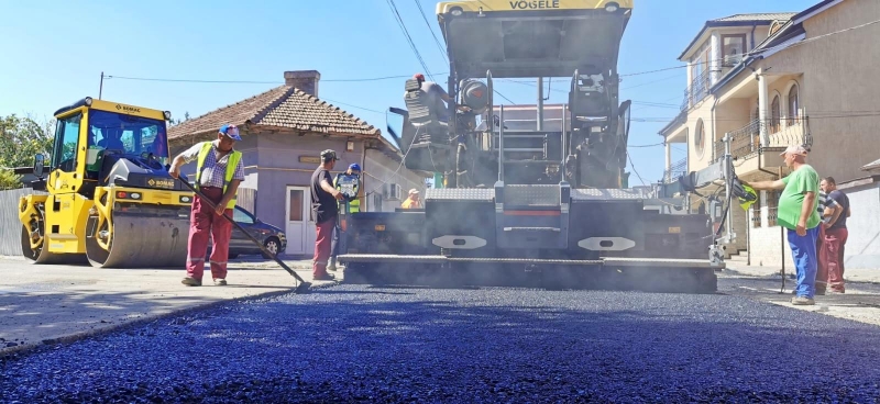 Lucrări de modernizare a carosabilului în cartierul KM 4: S-a turnat primul strat de asfalt pe strada Nehoiului!
